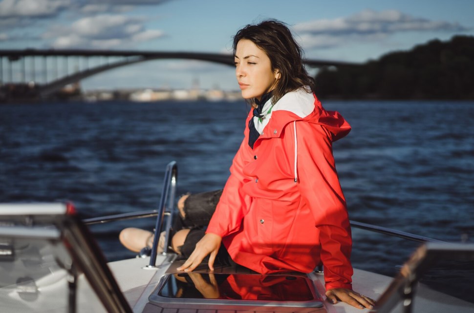 a beautiful young Asian woman in a red jacket on a yacht