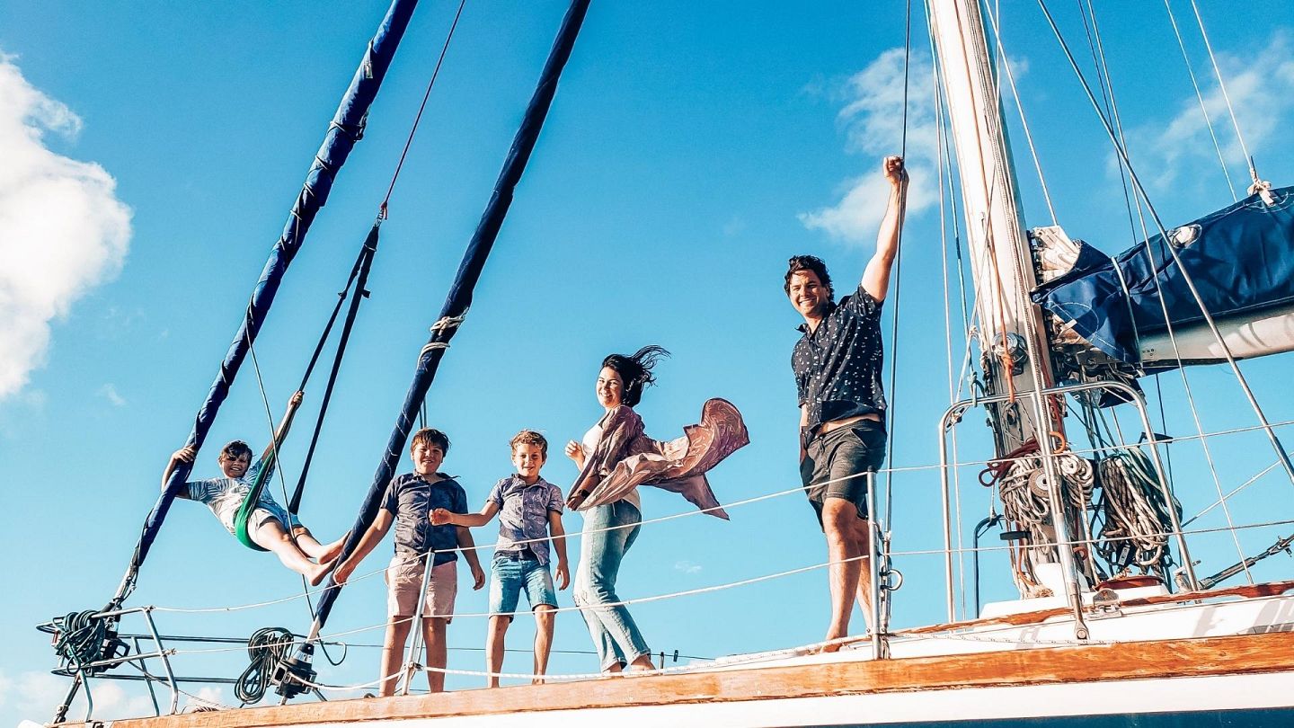 man, woman and children on a yacht