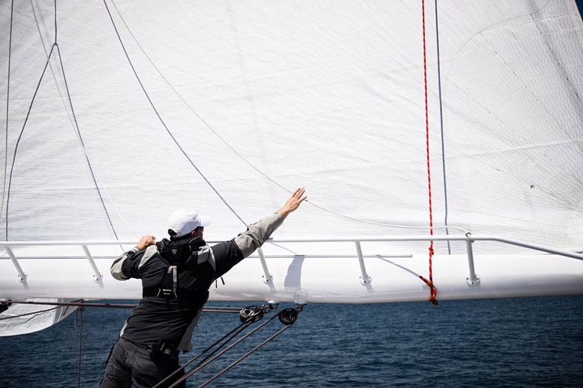 A man adjusts the sail on a ship