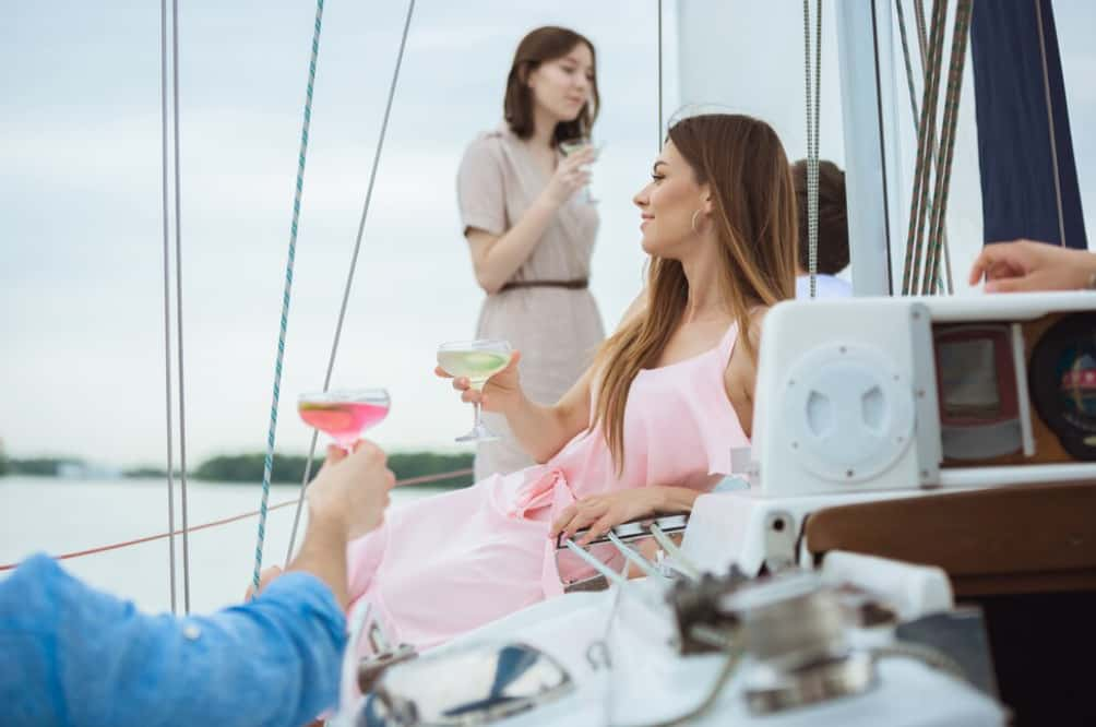 Guests enjoying drinks on a yacht with a stewardess serving