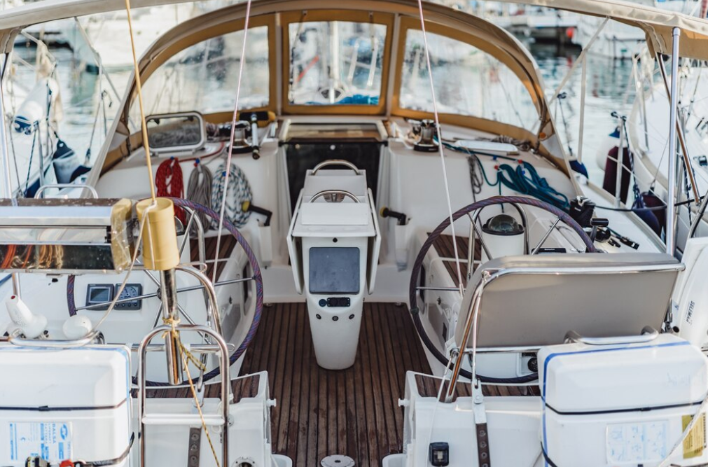 A sailboat cockpit with wheel steering and navigation screens