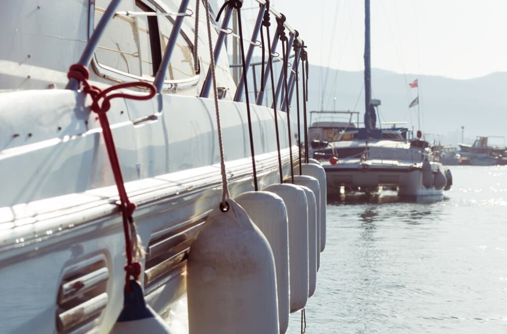 Side view of a sailboat with fenders hanging overboard